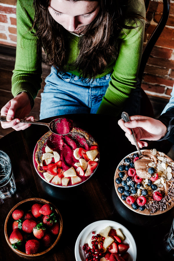 Customer eating smoothie bowls at a restaurant supplied by nutes superfoods
